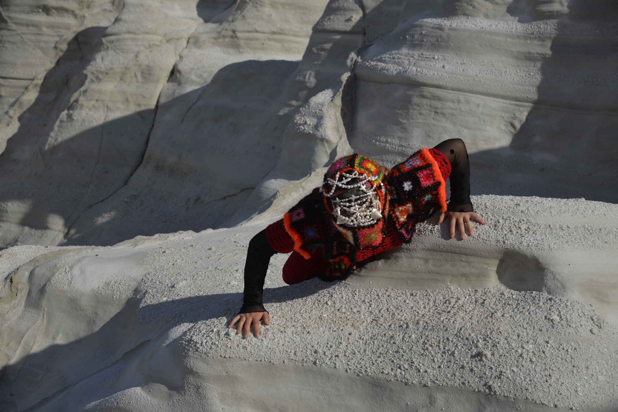 Red beetle figure moving through Sarakiniko