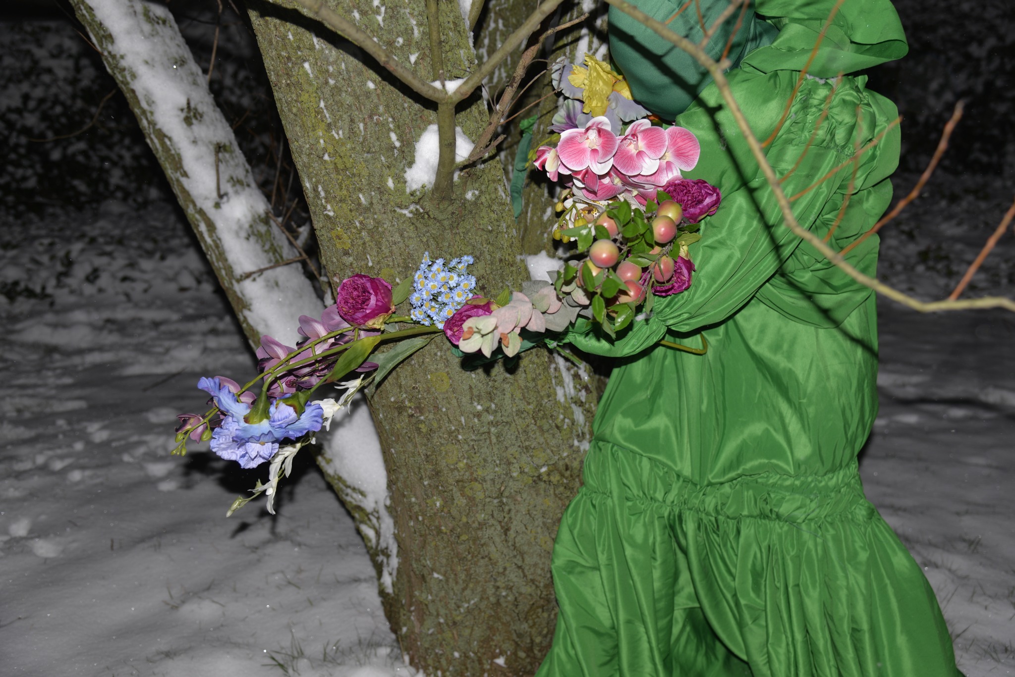 Flower goddess holding flowers beside a tree