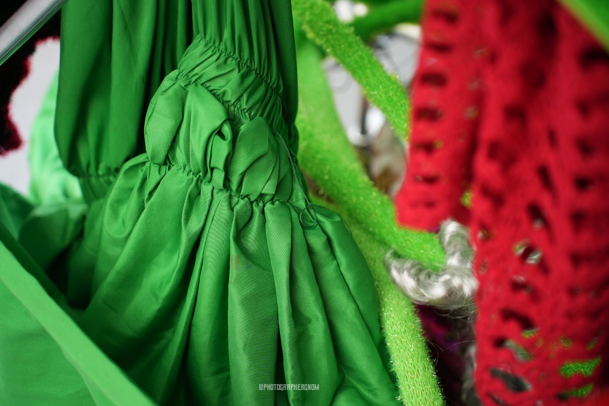 Gathered green fabric beside red crochet