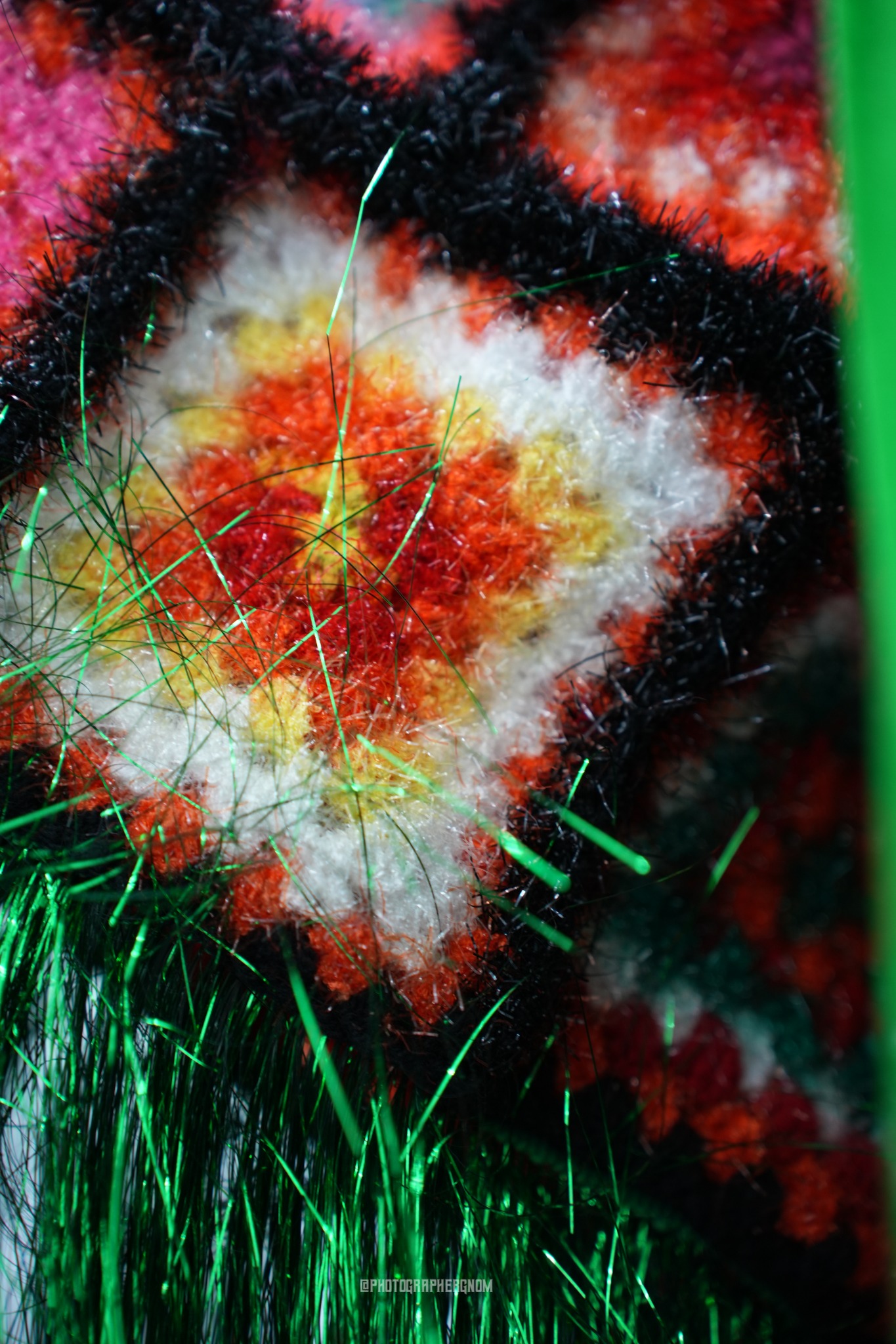Close view of red, white, black and green synthetic fibres