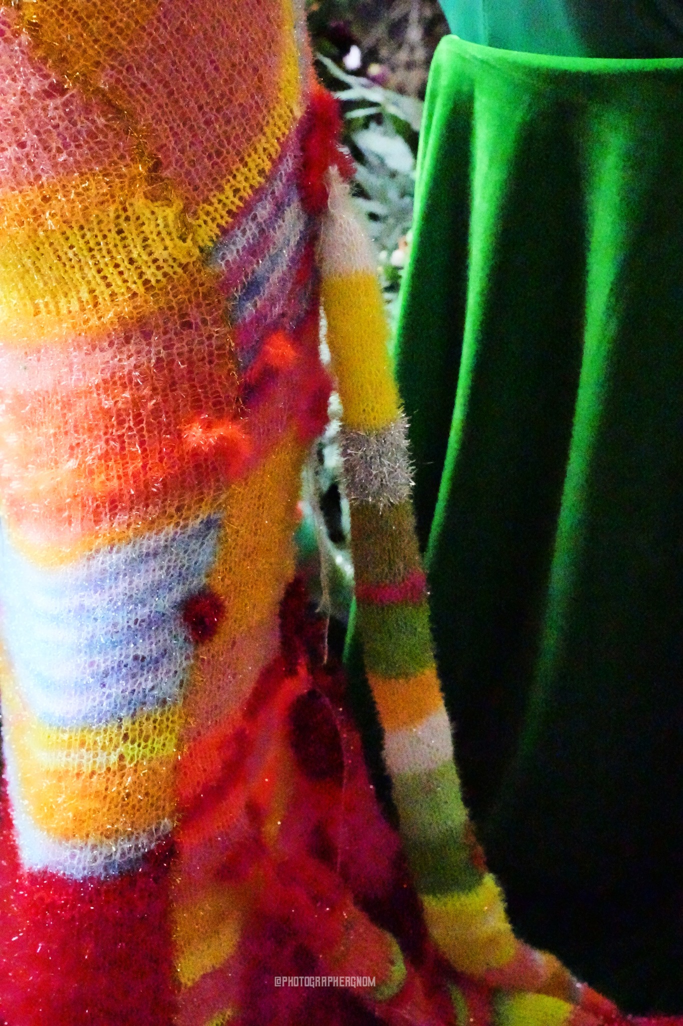 Striped knitted costume detail beside green velvet