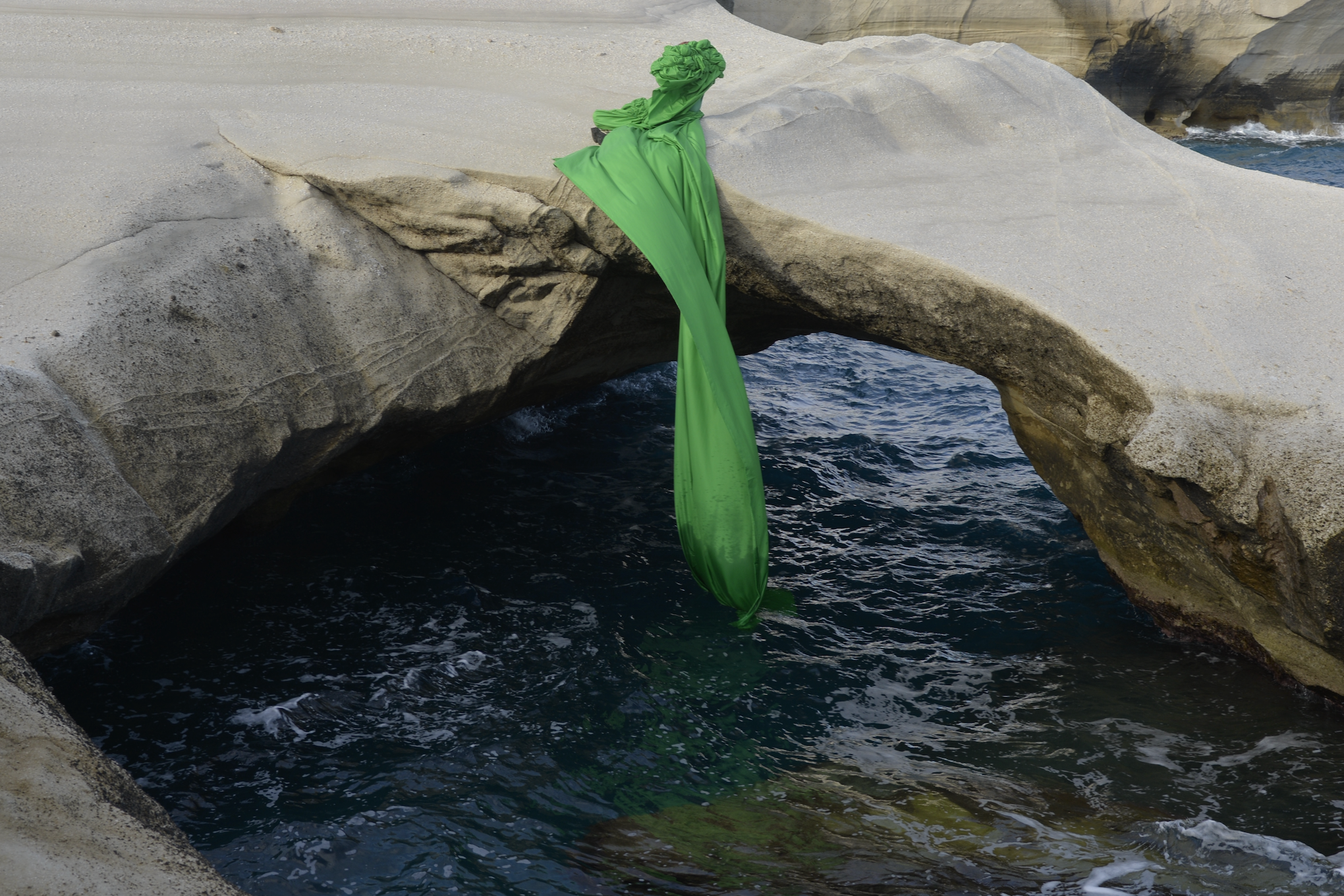 Venus figure seen between the rocks and the sea