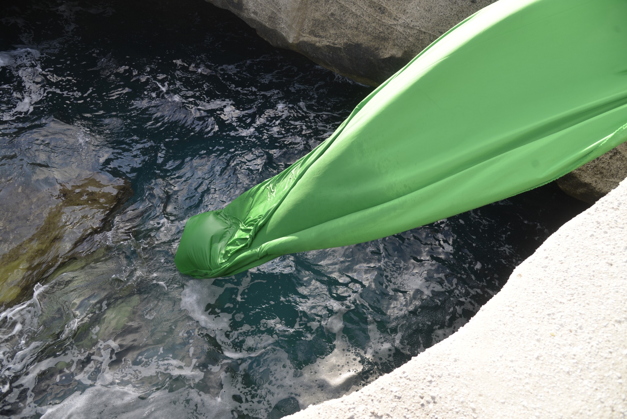 Green-screen fabric hanging into the sea