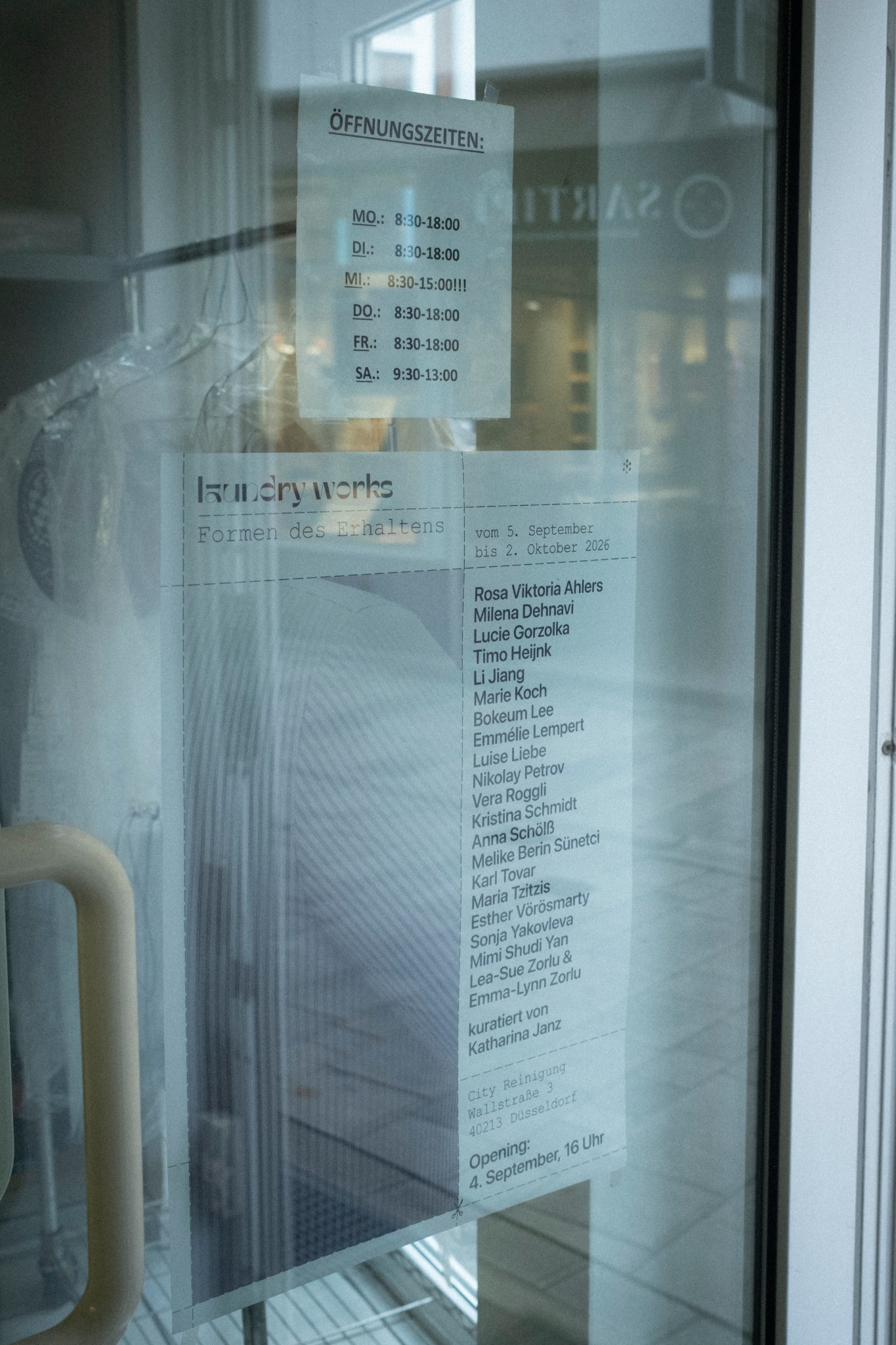 laundry works exhibition poster in the window of City Reinigung